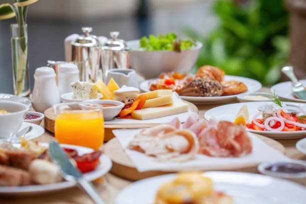Table full of various fresh food in luxury modern restaurant Table full of various fresh food in luxury modern restaurant. Delicious dishes, cold cuts, salmon, omelette, pastries, juices, cheese. Delicious and lavish breakfast or morning meal in high-end hotel buffet stock pictures, royalty-free photos & images