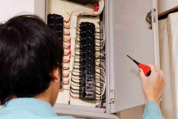 Household breakers and electricians An electrician is holding a screwdriver in front of the breaker. électricien résidentiel Beloeil stock pictures, royalty-free photos & images
