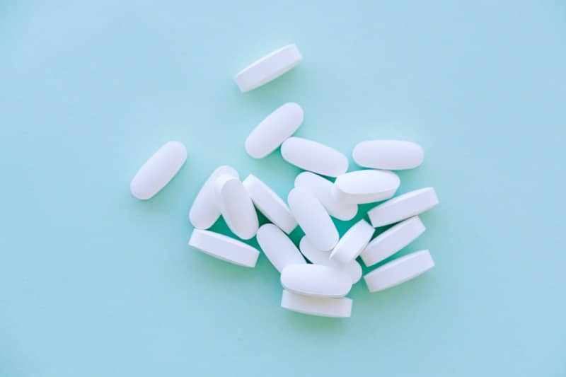 A pile of pills sitting on top of a blue table