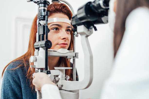Beautiful young woman receiving ophthalmology treatment. Doctor ophthalmologist checking her eyesight with modern equipment. Beautiful young woman receiving ophthalmology treatment. Doctor ophthalmologist checking her eyesight with modern equipment. lens for myopia stock pictures, royalty-free photos & images