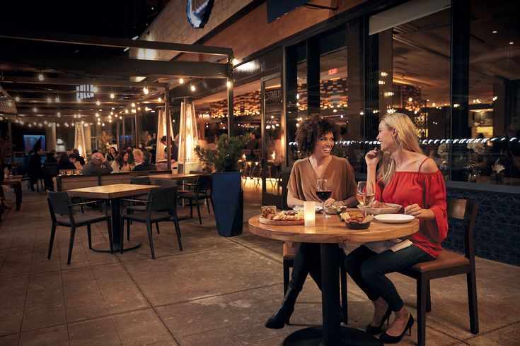 This may contain: two women sitting at a table eating food