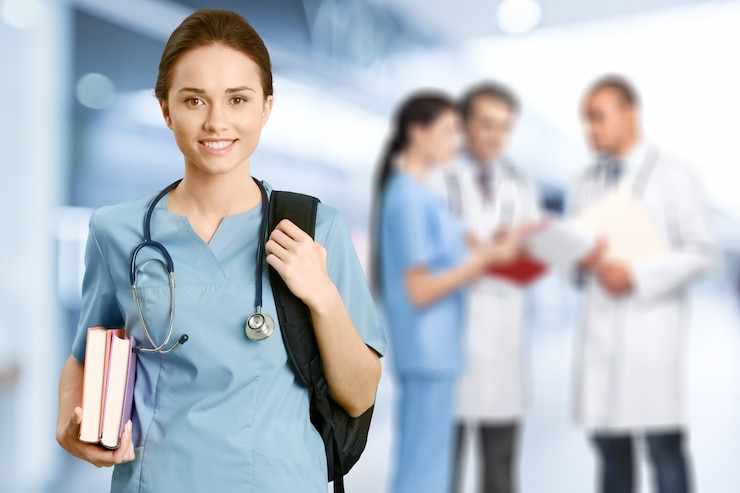 Attractive young female doctor with blurred hospital interior on background