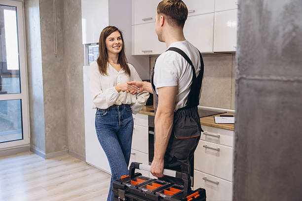 Plumber shaking hands with woman after finishing work in kitchen Plumber with toolbox shaking hands with homeowner in kitchen after finishing work, home repair service concept Plumber stock pictures, royalty-free photos & images