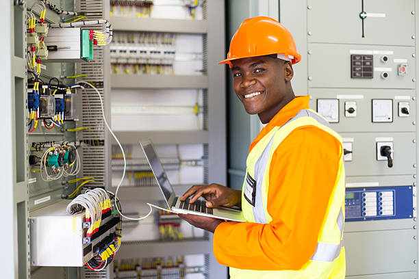 african electrical worker using laptop computer african electrical worker using laptop computer checking transformer  electrician  stock pictures, royalty-free photos & images
