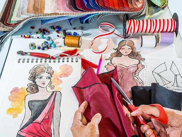 Fashion designer working with material and hand-drawn illustration Fashion designer's hands working with material and hand-drawn illustration sewing cutting table stock pictures, royalty-free photos & images
