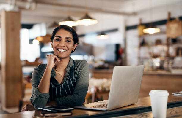 Nothing empowers you more than owning your own small business Shot of a young woman using a laptop while working in a cafe franchises businesses stock pictures, royalty-free photos & images