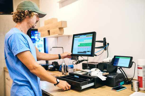 How much did we make today? Shot of a young man tallying up the sales for the day in his store franchise business stock pictures, royalty-free photos & images