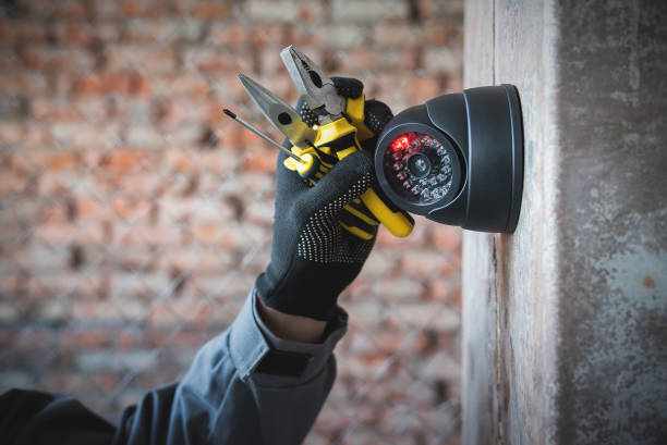 Security camera. Security camera on the wall close up and worker hand with a work tools. Video surveillance system maintenance concept. cctv  stock pictures, royalty-free photos & images
