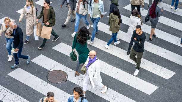 Large group of people walking across crosswalk in city top view Large group of people walking across crosswalk in city top view. Urban citizens crossing highway at rush hour, above wide shot cctv for crowd stock pictures, royalty-free photos & images