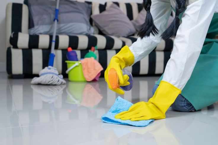 This may contain: a person in yellow gloves cleaning the floor with a mop and microfiber