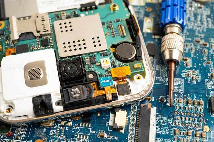 This may contain: the motherboard of a cell phone is being removed by a soldering tool on top of it