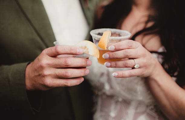 Bride and groom couple toasting alcoholic drinks together in celebration Bride and groom couple toasting alcoholic drinks together in celebration bridal dress usa stock pictures, royalty-free photos & images