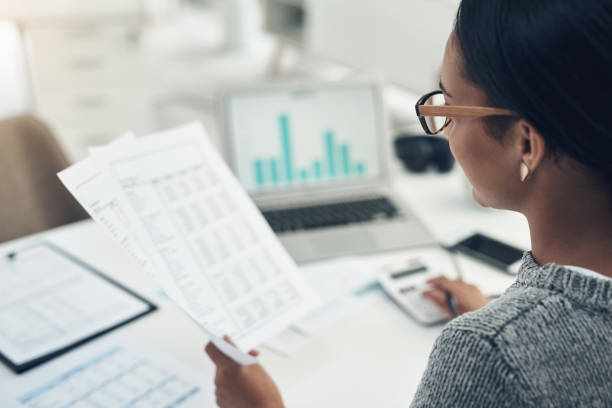 Closeup shot of an unrecognisable businesswoman calculating finances in an office Busy with her tax return filing tax saving stock pictures, royalty-free photos & images