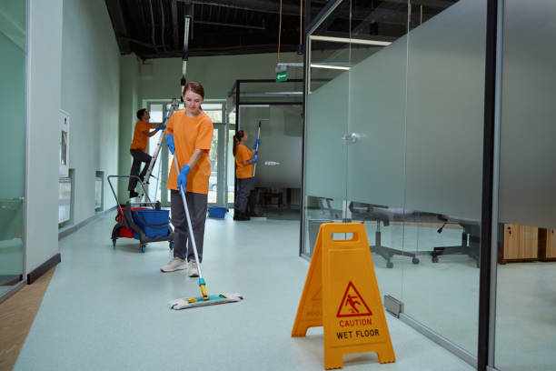 Young woman wiping floor with wet mop near warning sign Careful female cleaner using wet mop to wash the floor beside the yellow caution sign Commercial Cleaning & Janitorial Services stock pictures, royalty-free photos & images