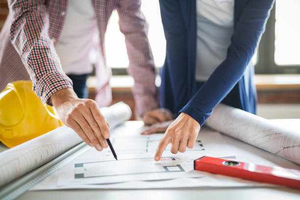Architects working with blueprints in the office. Architects working with blueprints in the office. Teamwork architects concept. architectural designers stock pictures, royalty-free photos & images