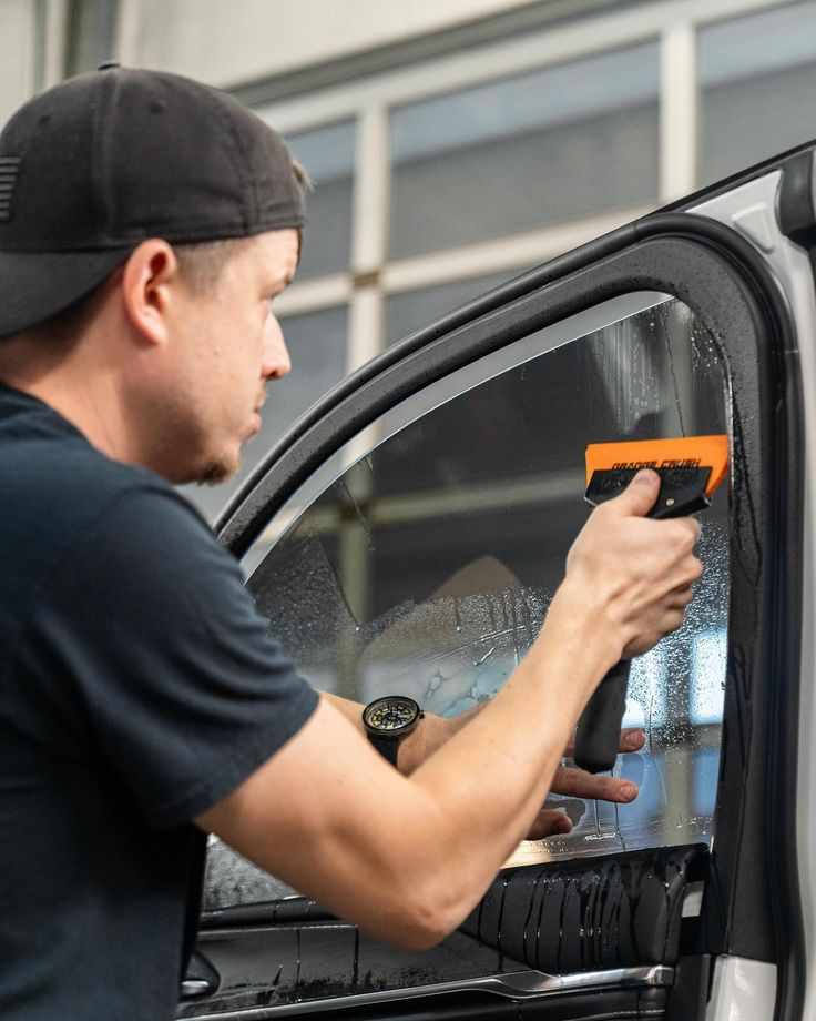 This may contain: a man is painting the side window of his truck